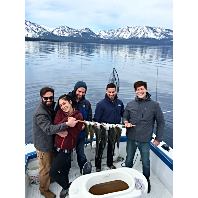 A group of people standing on top of a boat.