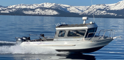 A boat is in the water near some mountains.