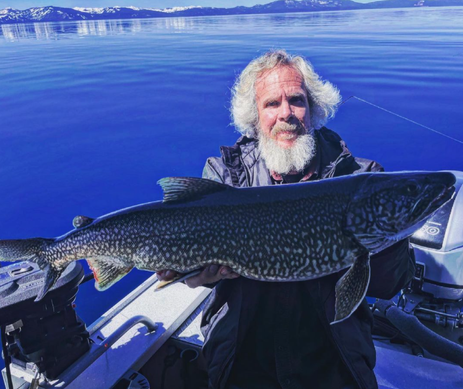 A man holding a large fish on top of a boat.